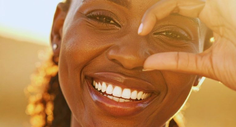 Femme au sourire radieux baignée de lumière dorée