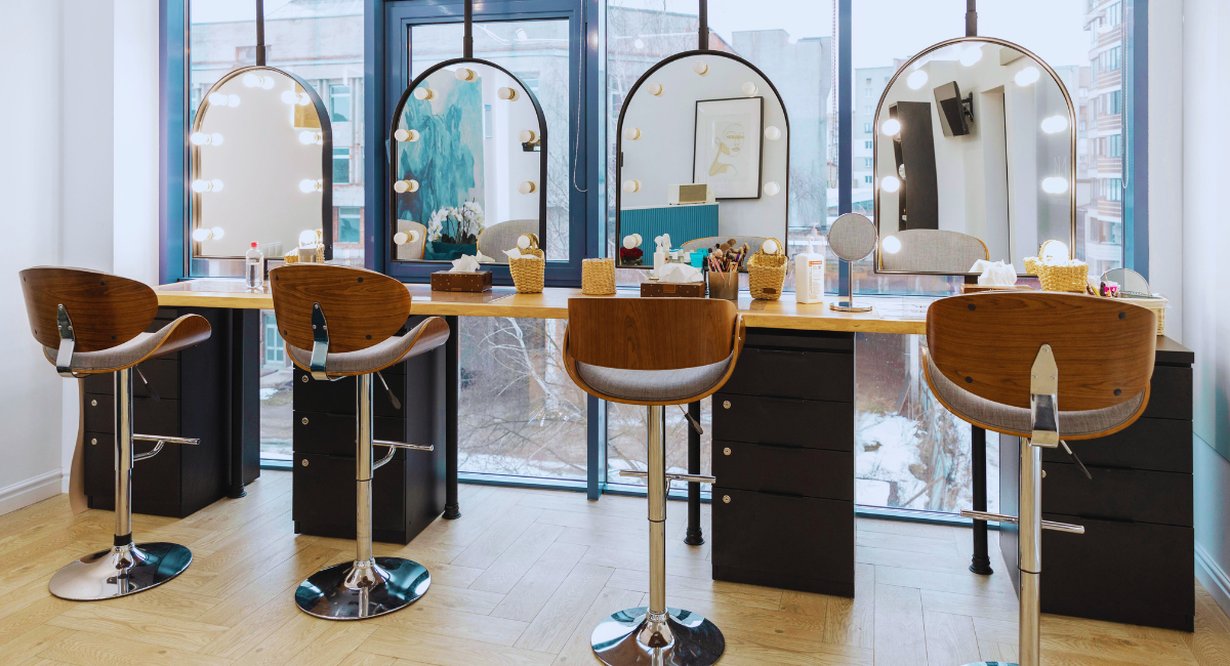 Espace maquillage d'un institut de beauté avec miroirs lumineux et tabourets