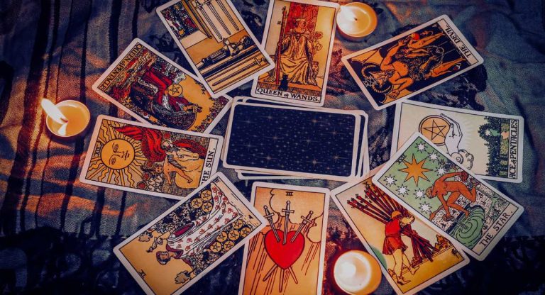Cartes de tarot disposées en cercle autour de bougies allumées
