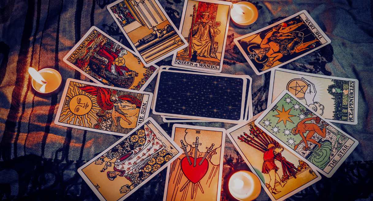 Cartes de tarot disposées en cercle autour de bougies allumées